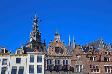 Fototapeta na wymiar Closeup of medieval gabled house facades with church tower against blue summer sky - Nijmegen, Netherlands