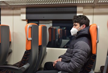 man with face mask sitting in the train