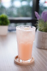 Refreshing cold beverage for summer on ice. Colorful summer drink in tall glass with wood saucer for hot day and party.