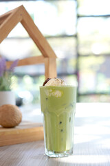 Green tea with milk or latte match with vanilla ice cream in cafe. Fresh and dessert in tall glass.