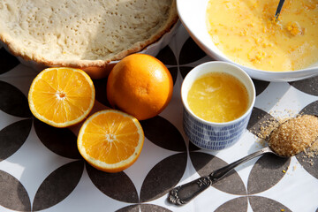Making orange pie. Close up photo of fresh ingredients. Crusty dough, oranges, sugar, eggs top view photo. 
