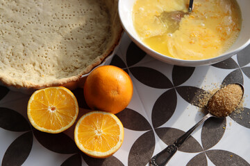 Making orange pie. Close up photo of fresh ingredients. Crusty dough, oranges, sugar, eggs top view photo. 