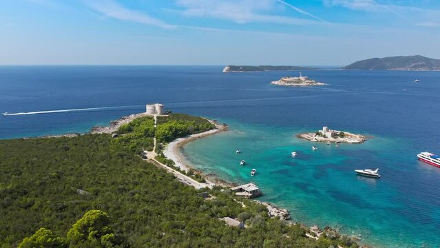 Top view of the island with a fortress. View from the Lustica peninsula to the island of Otocic Gospa. Castle on the island of Otocic Gospa. Montenegro. Drone. Catamarans in bay. Pleasure boats in the