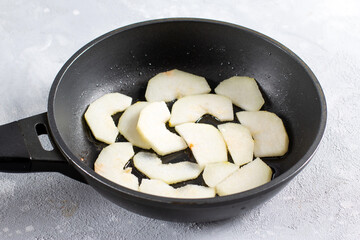 Fototapeta na wymiar Sliced fresh pear in a frying pan