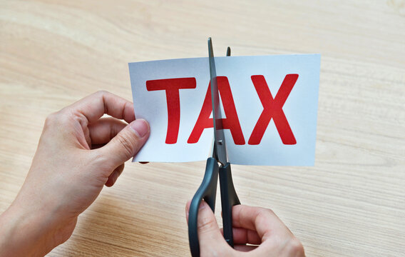 Hand holding scissors cut tax
