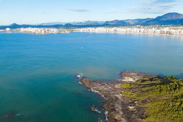 Fototapeta na wymiar Imagem aérea de drone da Praia do Morro em um dia ensolarado, com pessoas passeando, praticando esportes e descansando ao sol. Cidade de Guarapari no Espírito Santo