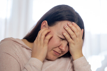 Fototapeta premium Pretty young woman suffering to strong tinnitus disease, sick female having an ear pain touching her painful head, healthcare concept