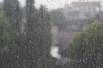 rain water wets the glass windows of the house