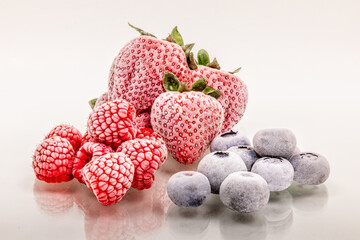 Assorted frozen fruits, strawberries, raspberries and blueberries on white background