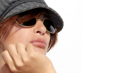 Close-up portrait of a confident young woman with modern sunglasses and peaked cap. Panorama banner with copy space on white background - obrazy, fototapety, plakaty