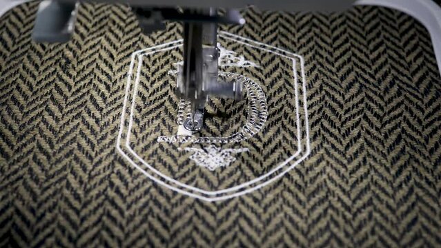 Embroidery design alphabet monogram D on brown fabrics embroider by machine. Close up. 4k video
