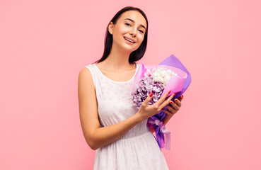 woman with rose flowers in her hands. Woman on a pink background, celebrating mother's day. March 8.