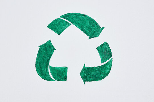 Dont be mean, keep it green. Shot of a green recycle symbol painted on a wall.