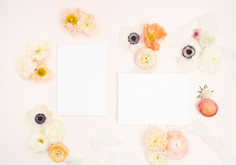 Fresh floral flat lay with anemones, roses and poppies, and blank stationery invitation cards