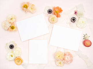 Blank stationery and fresh poppy rose and anemone flower flat lay on blush background