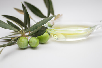 Olive oil in glass bowl with Fresh ripe green olives