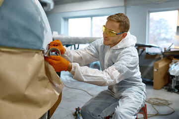Technician wrapping car with paper before painting