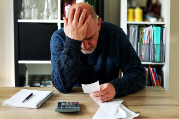 Man upset headache depressed from family cost got higher doing accounting holding receipts from...