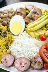 typical brazilian meal, rice and beans, tomato salad, boiled egg and french fries, called a traditional dish or executive dish