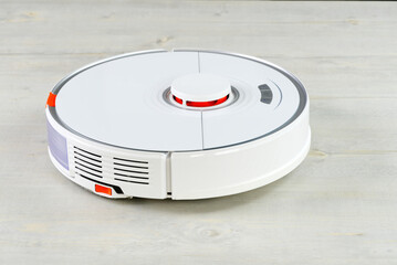 robot vacuum cleaner on the wooden floor cleaning the room. Smart cleaning and washing technology....