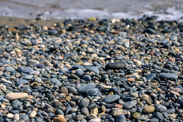 Stones and pebbles on sea beach in sunlight