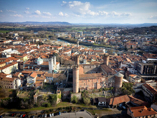 Aerial view of the historic centre with the Castle with its red towers in the foreground. Ivrea, Italy - March 2021