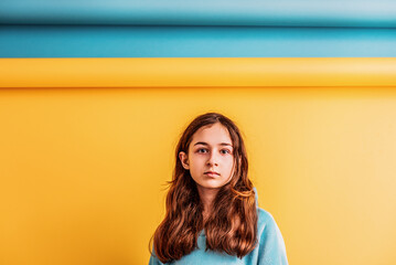 Girl for peace, stop war. Girl in a blue hoodie on a yellow and blue background.