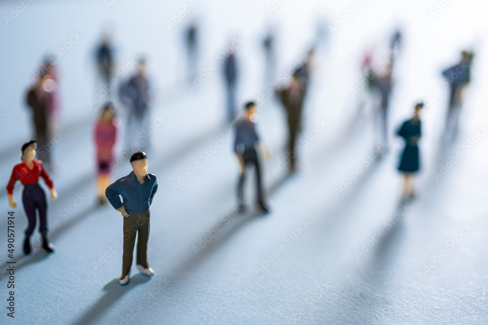 Wall mural a group of miniature people on a colored surface	