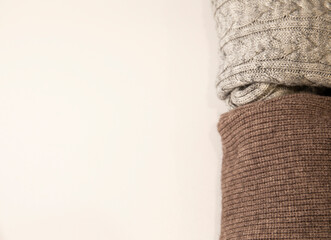 Pile of knitted warm sweaters clothes close up