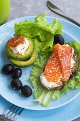 Healthy breakfast. Sandwich with smoked salmon, avocado cheese on lettuce salad leaves and coffee