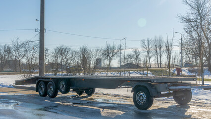 Open car trailer for transportation car for sale and evacuation wrecked car. Big empty open platform for passenger cars.