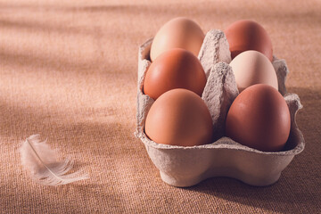 Fresh eggs in a cardboard box, on a beige background, no people, rustic style, selective focus,