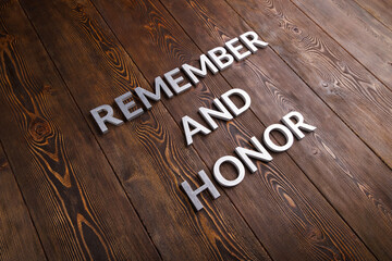 words remember and honor laid with silver metal letters on wooden background