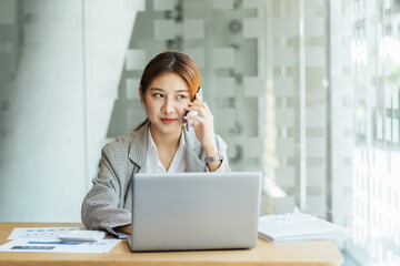 Closeup image of a beautiful asian woman holding and using mobile phone in office, business financial and investment concpet.