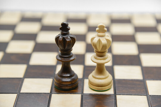 Black and white wooden figures for chess on the board