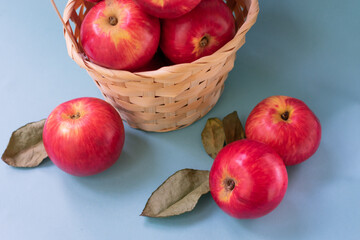 Juicy red apples on blue background. Top view of backet full of sweet appetizing red apples