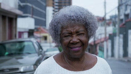 A happy senior black woman standing in a south american street looking at camera
