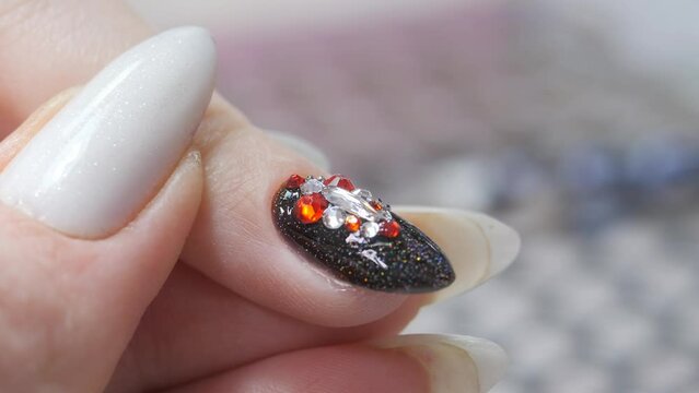 Applying a three-dimensional pattern with rhinestones and broths on the nail.