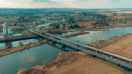 Blue railway bridge over the river Oder, Scinawa, Poland.  City view area drone photo
