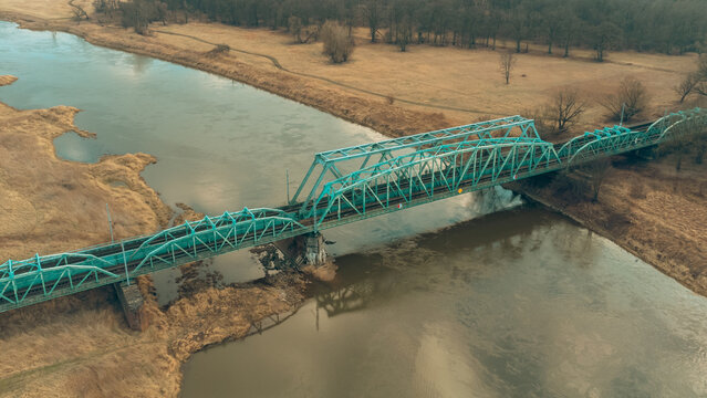 Blue railway bridge over the river Oder, Scinawa, Poland.  City view area drone photo