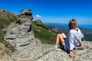 Fototapeta premium A girl on the background of ancient limestone high mountains. The Valley of Ghosts. Demerji. Crimea. 2021