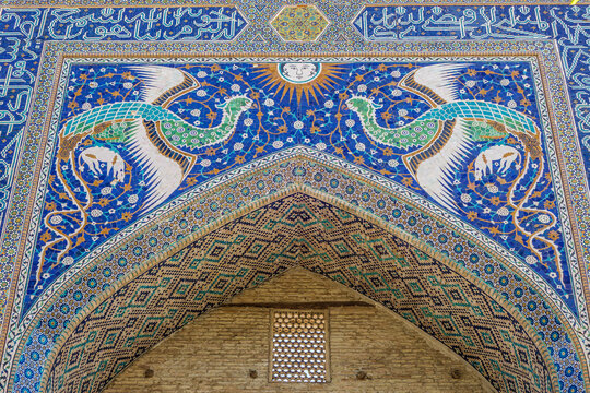 Close-up view of portal decorations of Nadir Divan-begi madrasah. In addition to classical patterns, facade is decorated with images of mythical Simurgh birds and sun. Shot in Bukhara, Uzbekistan
