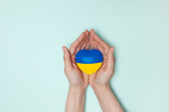 Heart with print the national flag of ukraine in female hands. Flat lay. Copy space.