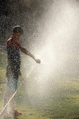 Obraz premium Children play with jets of water in hot weather
