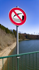 Plaque d'interdiction de se baigner au bord d'un lac de barrage.