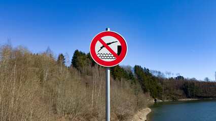 Plaque d'interdiction de se baigner au bord d'un lac de barrage.