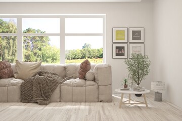 White living room with sofa and summer landscape in window. Scandinavian interior design. 3D illustration