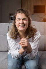 Disabled woman with organic damage of central nervous system smiles and looks at camera sitting on...