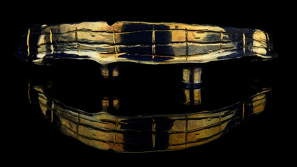 dental bar made of titanium with gilding on black glass with creative reflection