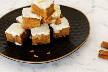 Vegan tofu and carrot cake with frosting. Cut cake cubes in tower.